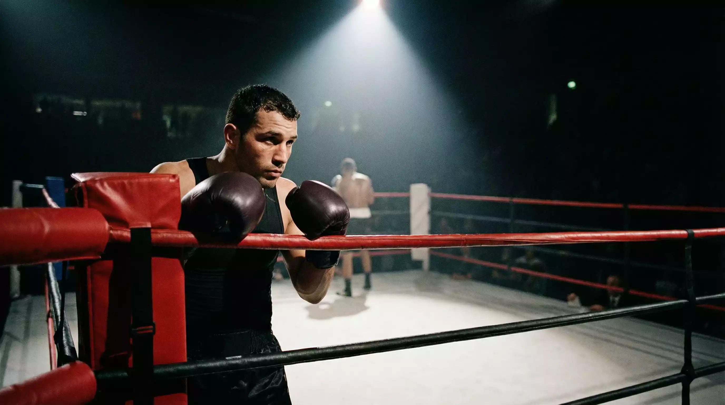 Boxeador profesional en guardia analizando a su rival desde la esquina del ring